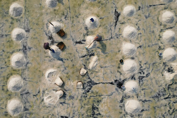  Aerial view of worker harvesting salt in salt field at Ban Laem-Thailand	