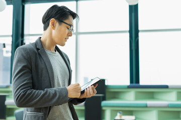 businessman working with tablet. man standing near window in relaxing place with copy space