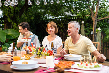 Multi-ethnic big family having fun, enjoy party outdoors in the garden. 