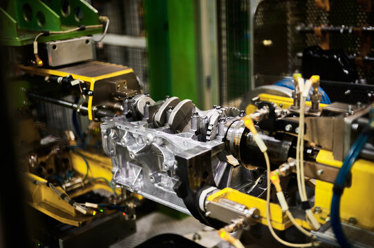 Illuminated car engine on test stand in production plant shop