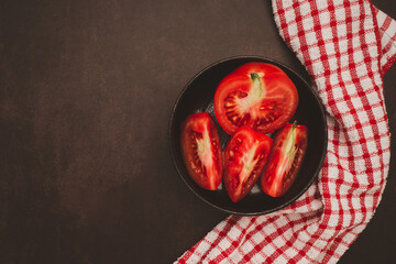 Fresh tomatoes in a black bowl on a table