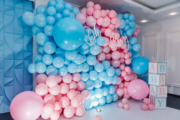 Photo zone, arch with pink and blue balloons, cubes for gender party. Boy or girl. Know gender of unborn child. Happiness of parenthood. Background, wall with text oh baby. Baby Shower party decor.