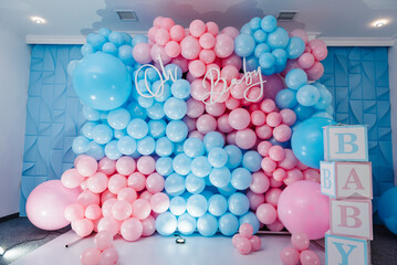 Baby Shower party decor. Photo zone, arch with pink and blue balloons, cubes for gender party. Boy...
