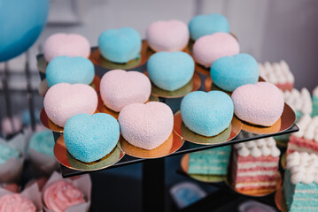 Table with pink and blue sweets for gender party. Baby Shower party decor. Delicious reception. Celebration concept. Trendy candy bar. Table with sweets, candies, dessert. Photo zone. Girl or boy.