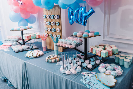 Baby Shower party decor. Delicious reception. Celebration concept. Trendy candy bar. Table with sweets, candies, dessert. Photo zone, arch with pink and blue balloons for gender party. Girl or boy.