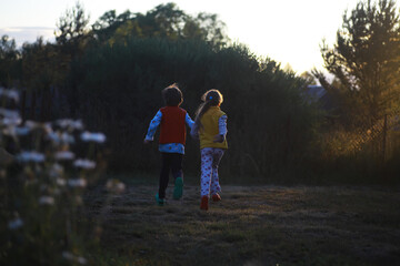 Obraz premium Children walk in the summer in nature. Child on a sunny spring morning in the park. Traveling with children.
