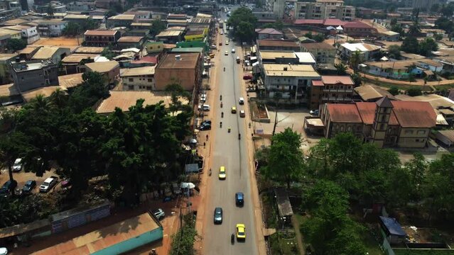 Drone shot tiltling over traffic in suburban Yaounde city, sunny Cameroon, Africa