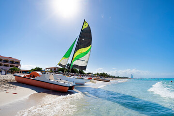 Fototapeta premium sailing catamaran is parked on the white sand on the seashore against the backdrop of beautiful tropical nature. tourist attractions in Cuba.