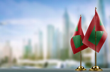 Small flags of the Maldives on an abstract blurry background