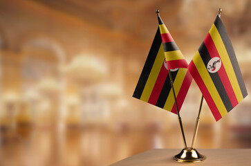 Small flags of the Uganda on an abstract blurry background