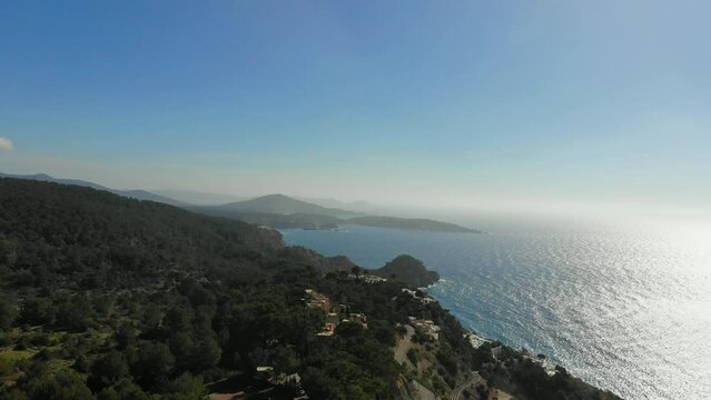 Drone rising by a building by the coast on Ibiza.