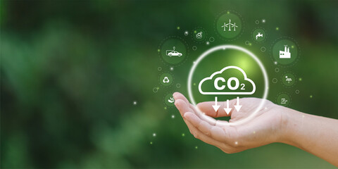 Businessman holding Co2 icon on virtual screen Reduce CO2 emissions to limit global warming. Lower...