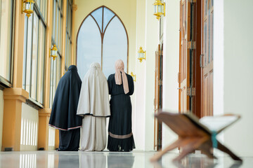 Many groups of Asian Muslim women in the Islamic religion in hijabs of cream and black color. She was praying in a beautiful mosque out of respect for God.
