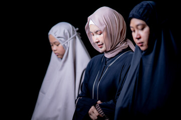 Many groups of Asian Muslim women in the Islamic religion in hijabs of cream and black color. She was praying in a beautiful mosque out of respect for God.