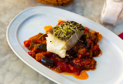 Popular dish of Spanish cuisine is Bacala, made from fish with vegetables and decorated with greenery on top