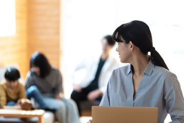 自宅で仕事をする女性とくつろぐ家族