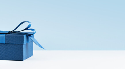 Part of Luxury gift box with a blue bow on light blue. Side view monochrome . Fathers day or...