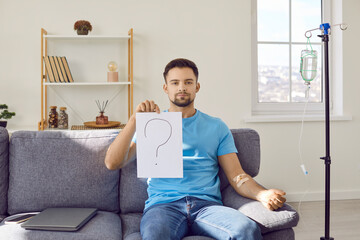 Patient doubting effectiveness of treatment therapy. Young man sitting on couch at home, getting...