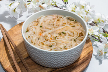 Korean noodles Ramen with broth. Hot dish, chopsticks, hard light, dark shadow