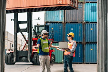 Team Engineer and worker wear safety uniform check control loading freight cargo container use computer laptop at commercial dock warehouse,transportation import,export logistic industrial service