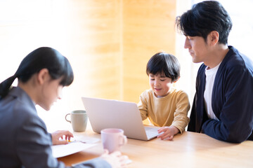 パソコンを見る父子と宿題をする女の子