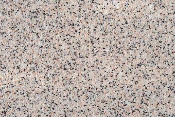 Grainy kitchen countertop top view. Surface of spotted empty table, abstract background with small black and white stones, rough material, grain light brown pattern.