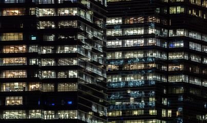 Fototapeta na wymiar Illuminated windows at night in downtown SIngapore