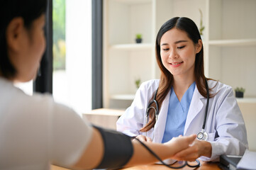 A professional Asian female doctor checking patient's pulse, heart rate and blood pressure