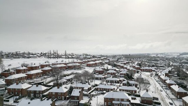 Urban Winter Scene. Aerial Drone Video Footage showing a snowy landscape in a suburban UK town.