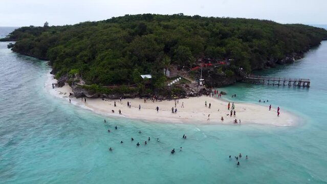Aerial close up drone view of Sumilon island white sandbar beach, with tourists swimming in tropical blue clear water, a small island  just off the coast of oslob in Cebu philippines
