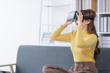 Surprised Young latin or asian woman in VR headset touching air, Smiling white woman wearing vr glasses while sitting on sofa at home.