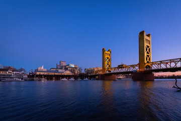 A view of Tower Bridge in Sacramento, CA from River Walk Park at dusk