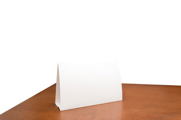 White paper sheet tent card on wooden table white isolated background can insert customer message. clipping path. Stand mockup frame menu card