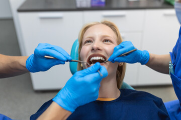 Close-up of a dental drill procedure at dentist approaching a patient with dental instruments held...