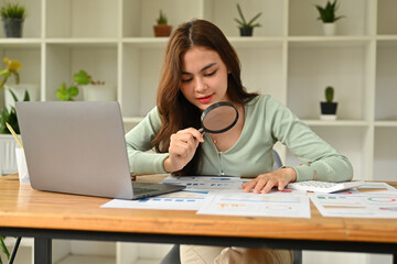 Businesswoman using magnifying glass finding invest in Stock market or forex trading, analysis graph an candlestick chart, Auditing tax, Analyze return on investment, review balance sheet annual.