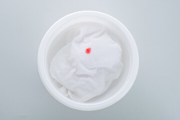 Soaking clothes  with a blood stain in a white basin. Use cold water. top view. daily life stain concept