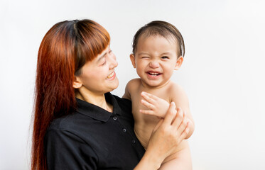 Happy mother with her baby on isolated white background. Mom wearing black shirt holding her son and smiling merrily. Young attractive happy mother smiling hugging looking at her little baby.