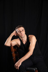 a man posing on a black background in a dark room