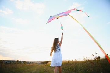 one happy little girl running on field with kite.