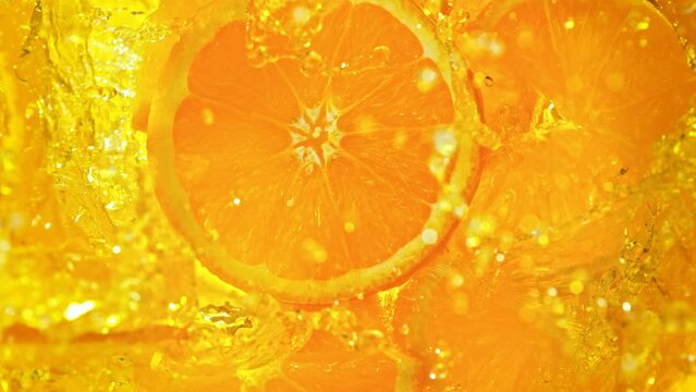 Super Slow Motion Shot of Fresh Orange Slices Falling into Lemonade Whirl at 1000 fps.