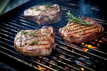 Tuinposter Beef steak on the grill with smoke and flames.  © Katynn