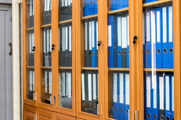 Wooden and glass office binders cabinet that hold a large number of binders in an office to keep...