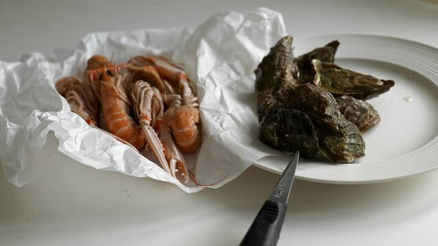 Fresh prawns and oysters from fish market on paper and plate on table