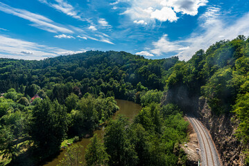 Sazava river with forest covere hills and railroad track with tunnel near Sazava town in Czech republic