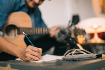 A songwriter or composer, Close up of songwriter hands composing sheet music writing on paper Professional songwriter with audio recorder digital music production. - obrazy, fototapety, plakaty