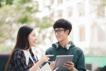 Asian students joining study book reading together.