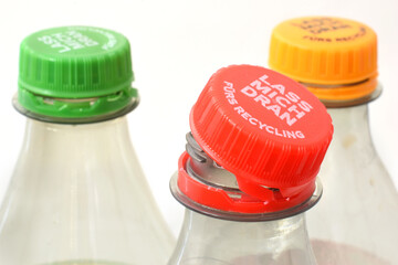 Bottle tethered cap is together with plastic bottle. Editorial illustrative image of environment friendly recycling. Text on cover "Let me stay" is on German language.
