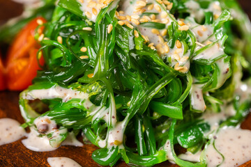 Traditional Japanese wakame salad with sesame seeds - asian food. Healthy and fresh seaweed salad close up