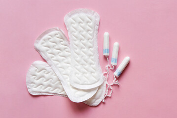 Feminine sanitary pads pattern and tampons on pink background. Hygiene care during critical days, caring for women's health. Daily and monthly protection. copyspace. menstrual cycle.