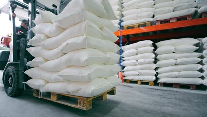 Unloading of large white bags from long-term storage of bulk products.